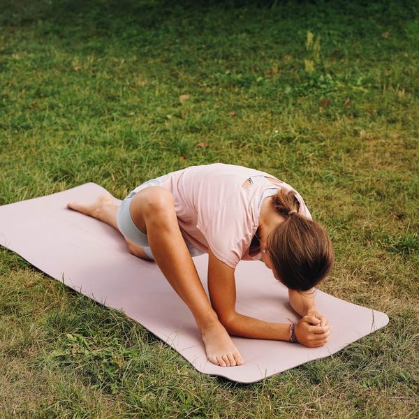 Person in a state of calm balance during a movement practice outdoors.